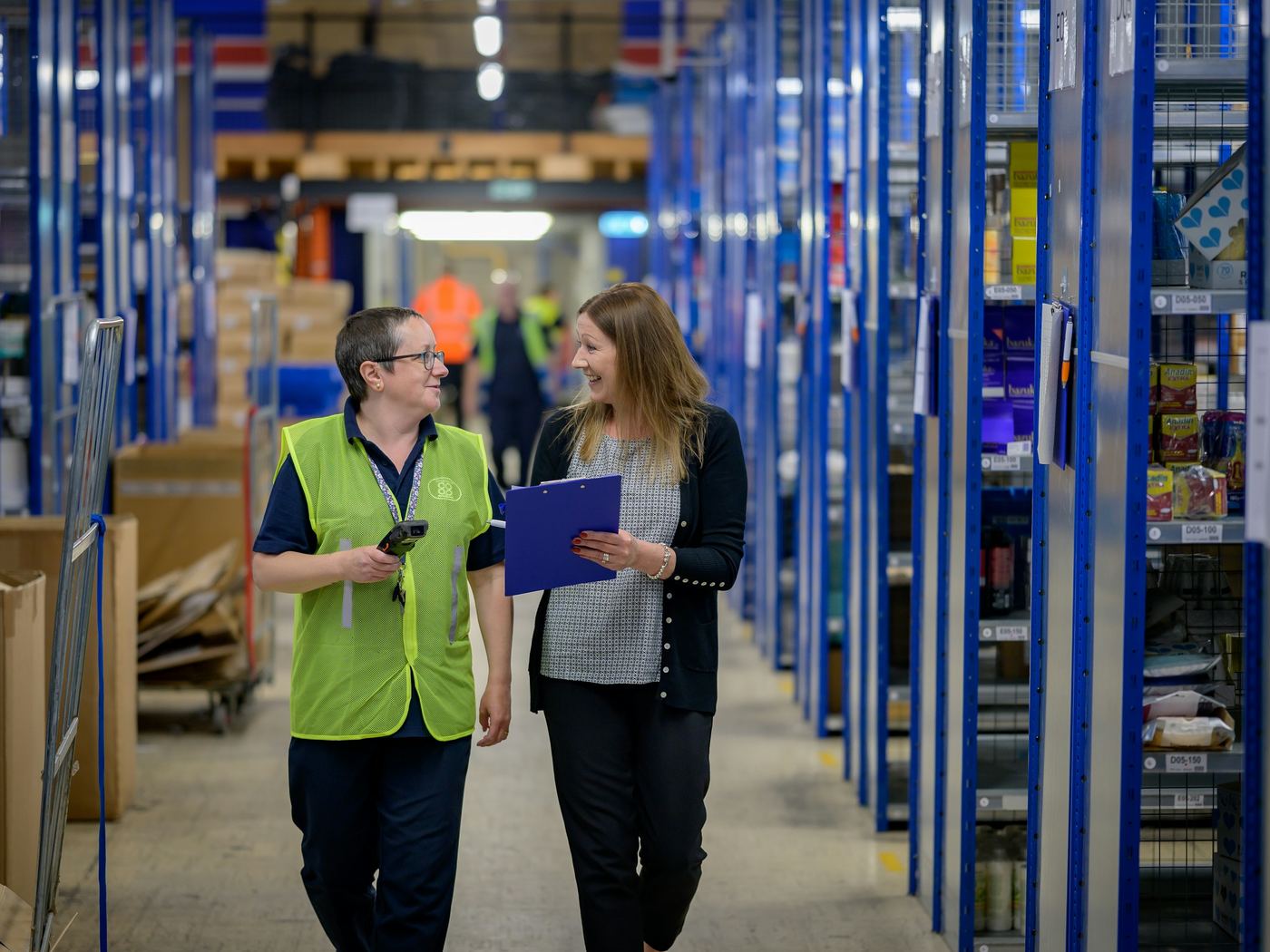 A store manager and a sales associate walking the aisles together, talking.
